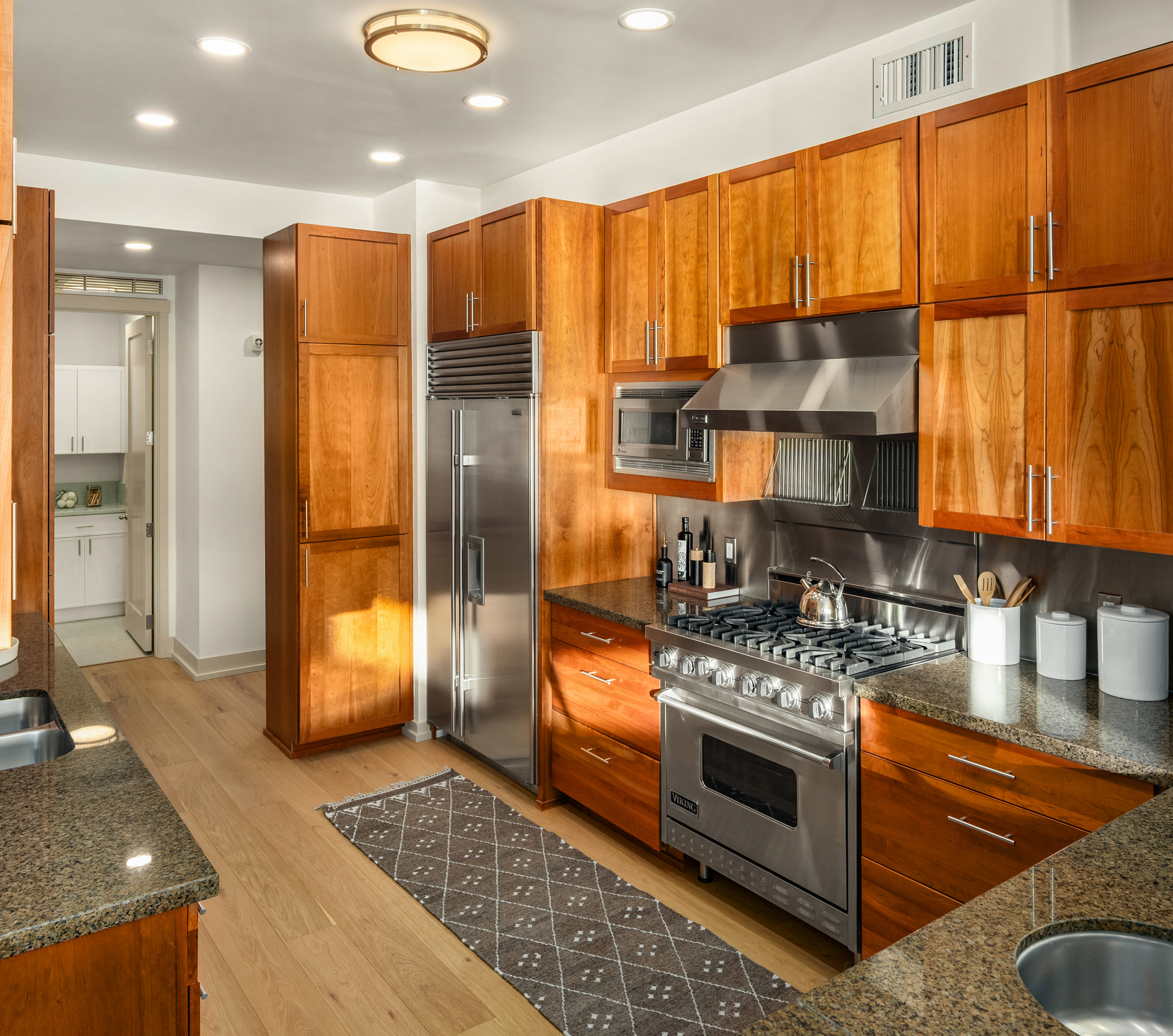 Full kitchen with wood cabinetry and stainless steel